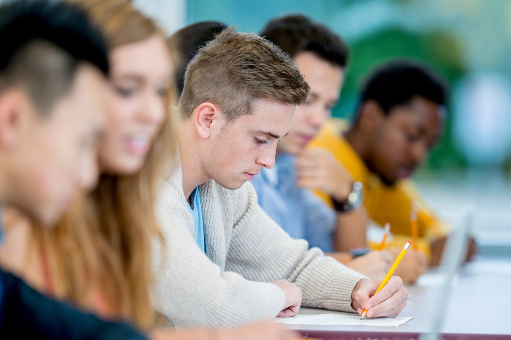 Ein Student macht sich Notizen während eines Seminars.